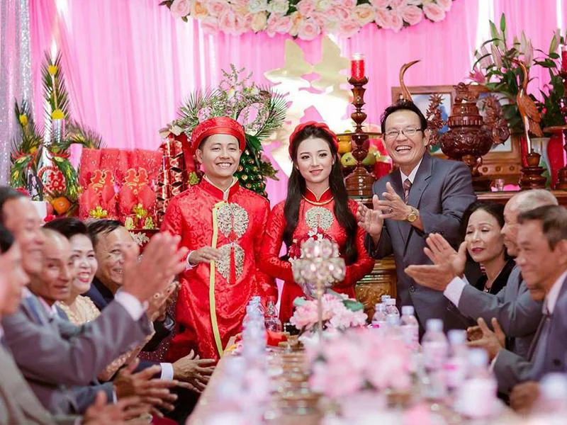 Cô dâu chú rể mặc áo dài đỏ truyền thống trong lễ cưới hỏi Hà Tĩnh trước bàn thờ gia tiên trang trí trang trọng